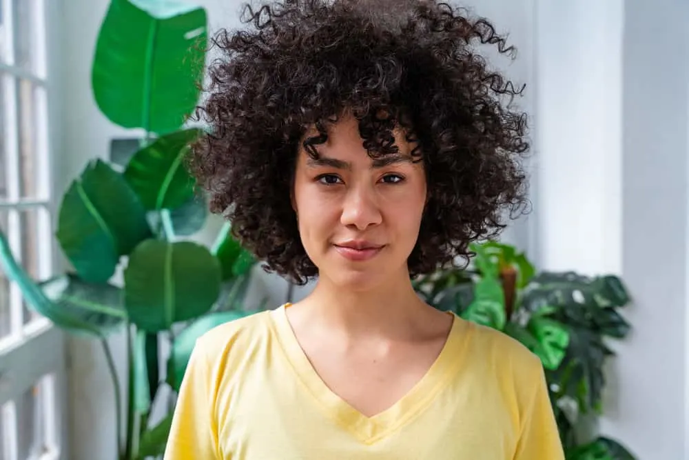 Does Rice Water Expire? Can You Use Old Rice Water? 4 A Latino woman enjoying the nourishing hair benefits of using prepared rice water on her weak hair strands.