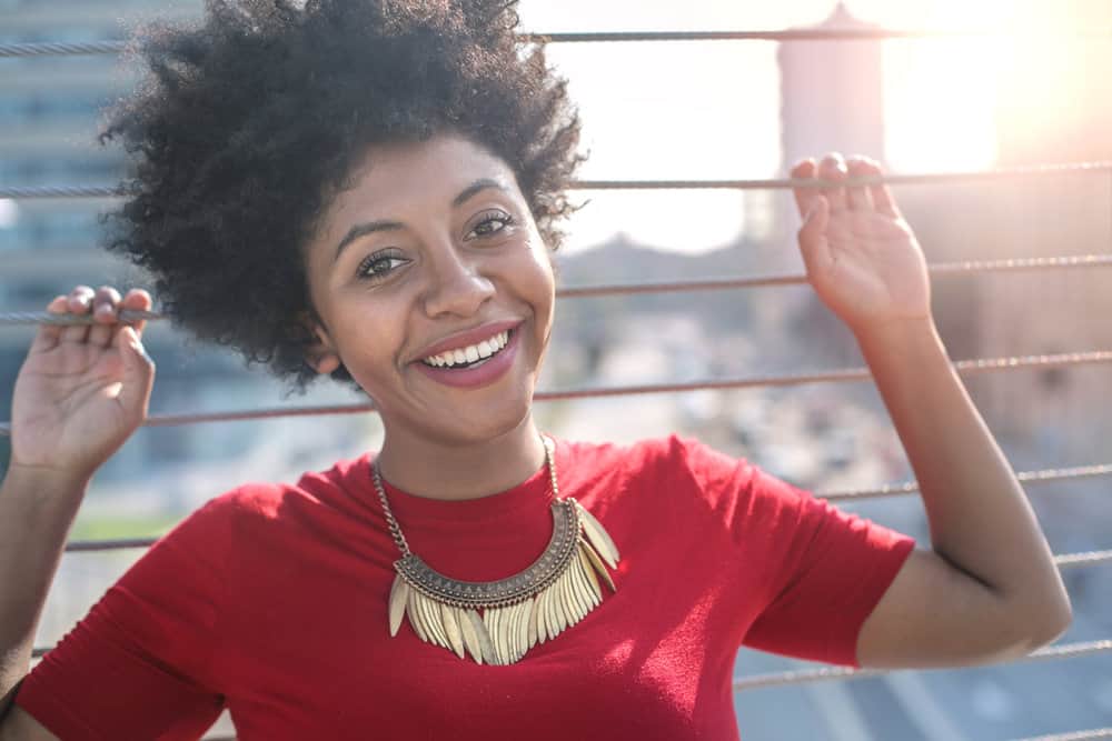 Positive African woman after getting a haircut at her local Great Clips hair salon using the online check-in process.