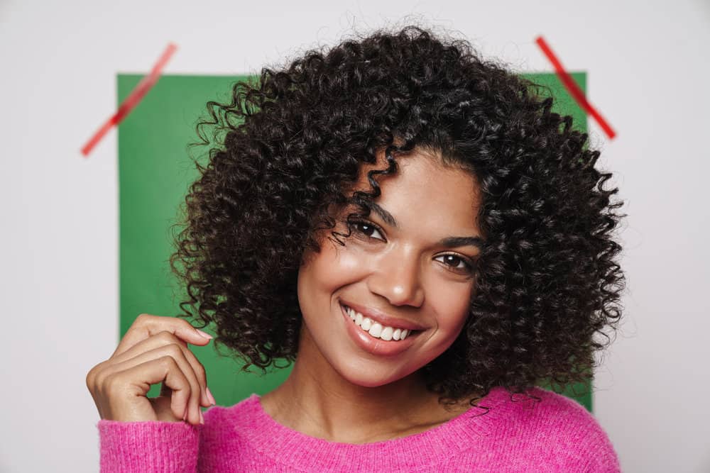 Young African American female with new hair growth after dealing with scalp itch from oily buildup.