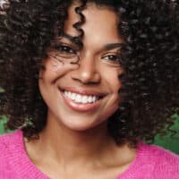 A young African American female with a flaky scalp is looking for hair products to treat dandruff on an oily scalp.