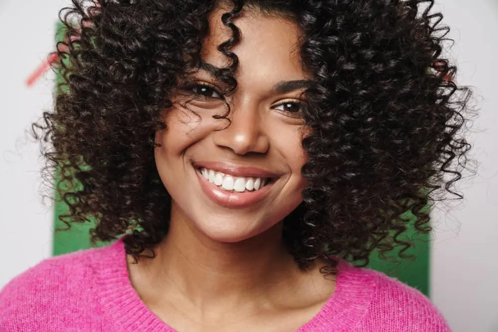 Why Do I Still Have Dandruff After Washing My Hair? 1 A young African American female with a flaky scalp is looking for hair products to treat dandruff on an oily scalp.