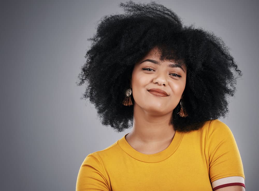 An attractive young African American woman with dark hair sees her hair turning golden brown.