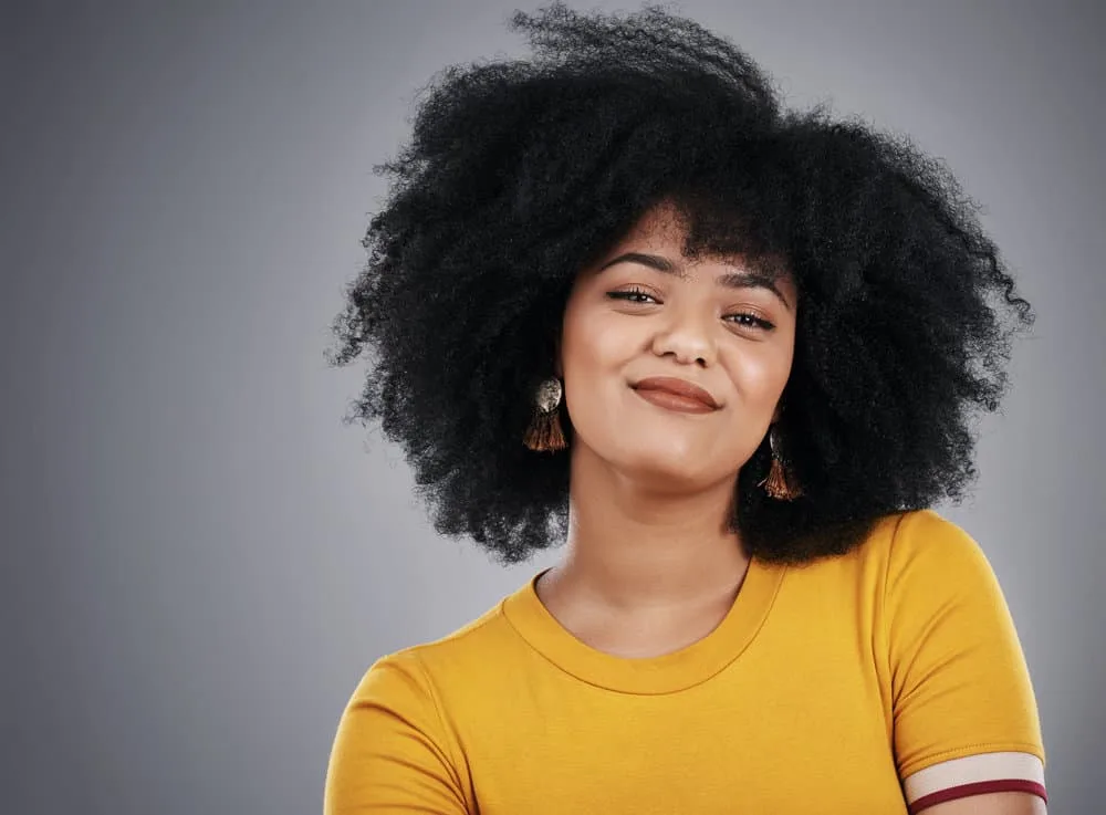 Why Is My Black Hair Turning Gold? 4 Causes & 3 Quick Fixes 1 An attractive young African American woman with dark hair sees her hair turning golden brown.
