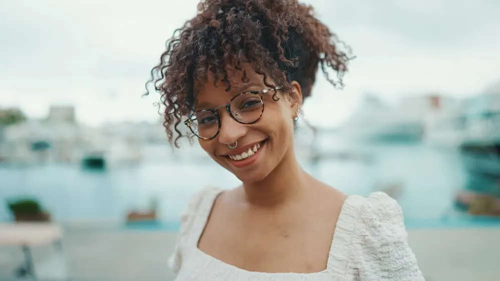 A black lady wearing her hair wavy after experiencing hormonal changes that caused her curly hair to turn straight.