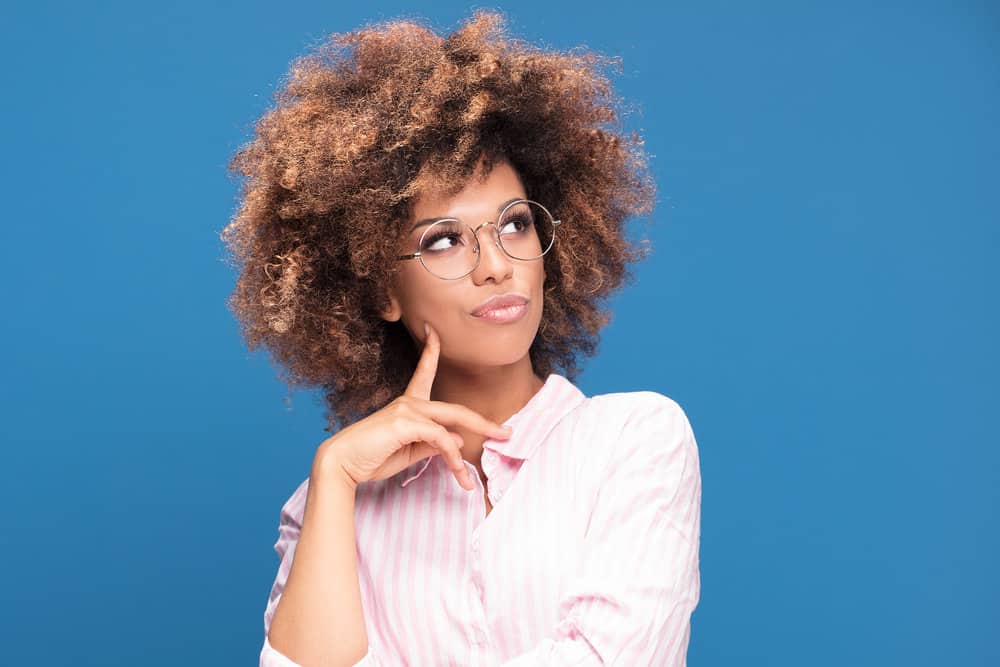 A young black woman wearing expired semi-permanent dye (leftover box dye) to create light brown highlights.