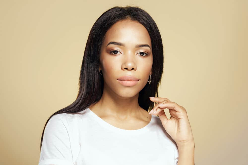 A young light-skinned girl with dry hair after flat ironing her damp hair with a wet-to-dry heated tool.