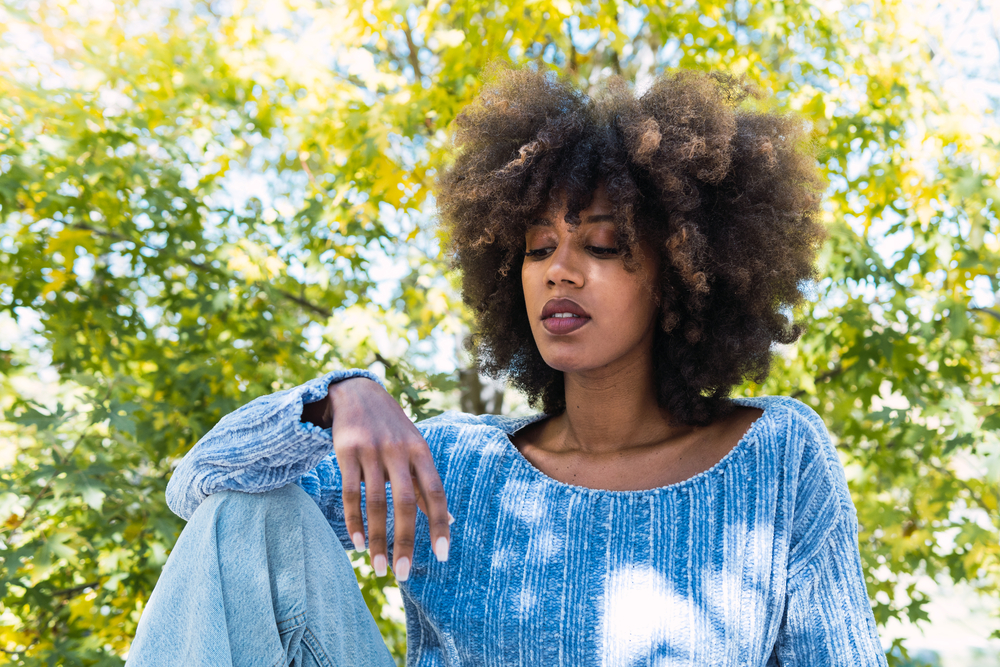 Young black girl with low hair porosity after using a rice water rinse for healthy hair growth and deep conditioning.