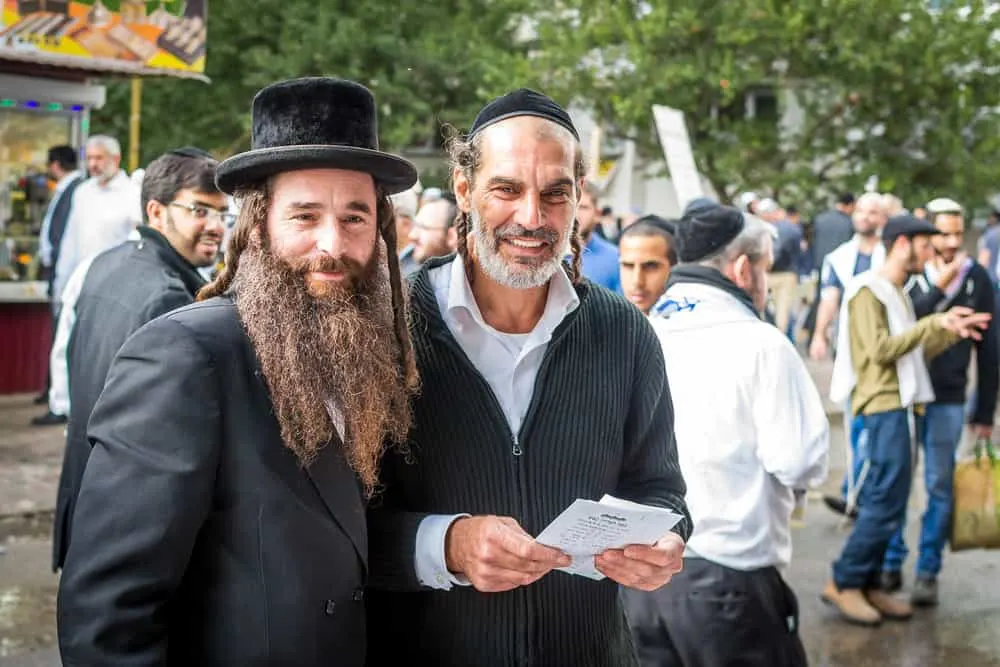 Two orthodox Jews with thick dark curls exhibiting overwhelming Jewish diversity (e.g., Jewish noses).