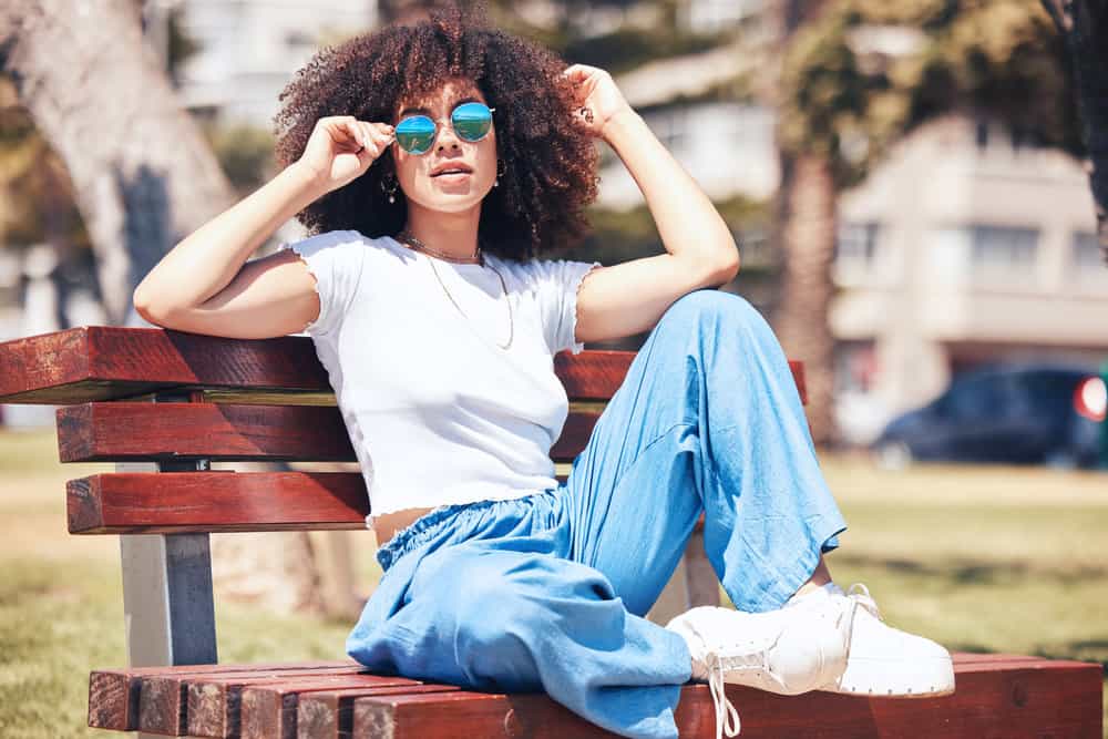 A young mixed-race woman with a beautiful head of healthy curls after experiencing excessive hair fall two years ago.