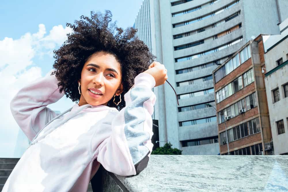 A cute female with low porosity hair and natural curls washed with shea butter shampoo due to her dry hair strands.