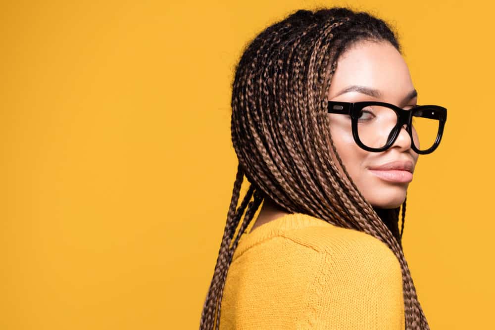 A messy braid hairdo is worn by a fashionable young lady with effortlessly stylish haircuts for big foreheads.