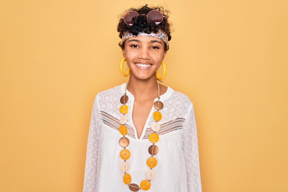 A cute young black girl with fine hair has her own personal style wearing the bixie haircut trend on an oval face shape.