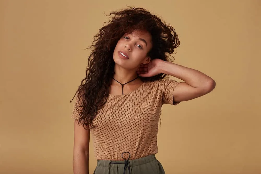 How to Do a 90s Blowout Style at Home on Short or Long Hair 7 Attractive young woman with big hair styled with velcro rollers that work wonders to recreate a 90s look.