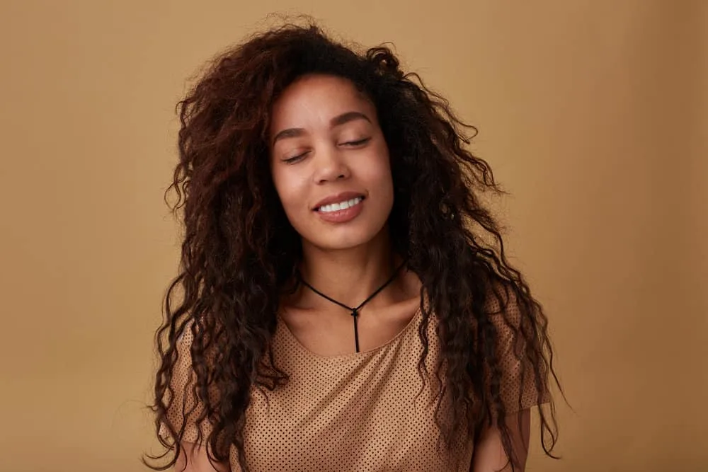 How to Do a 90s Blowout Style at Home on Short or Long Hair 6 A pleasant lady with a great smile after getting a protein treatment on her dark brown, mid-back length locks.