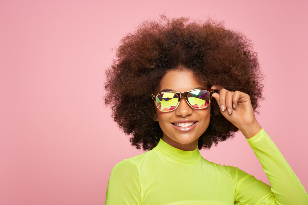 African American female wearing a stunning curly wash and go hairstyle with face-framing layers.