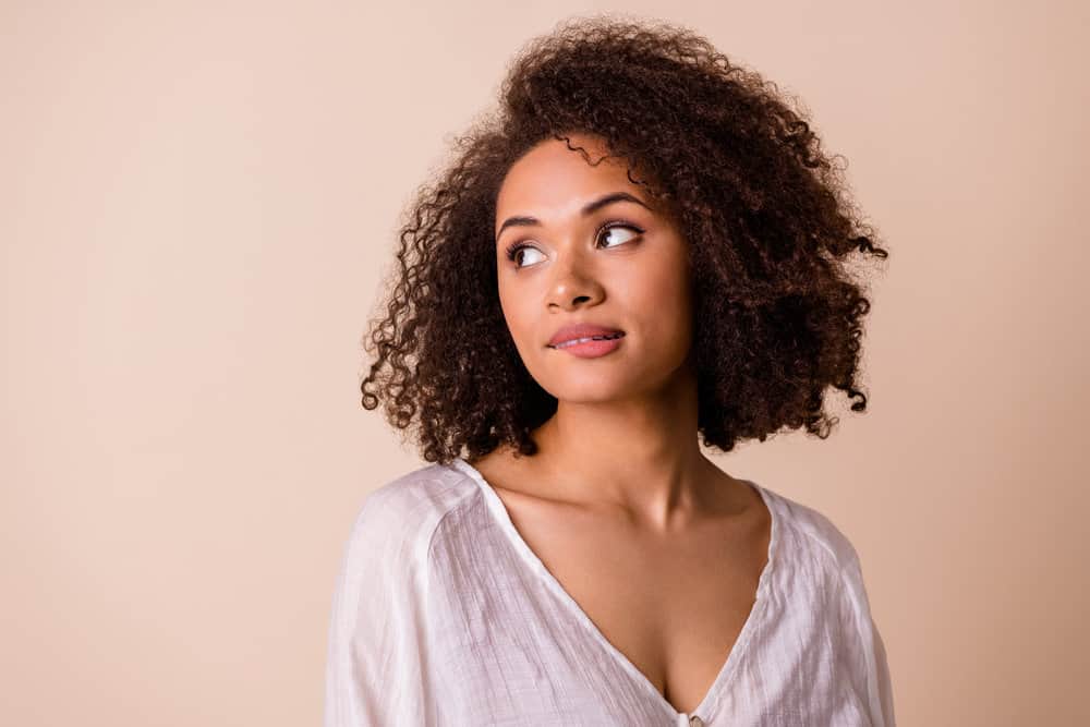 A cute African American female with hair shaft damage after coconut oil damaged her low porosity hair strands.