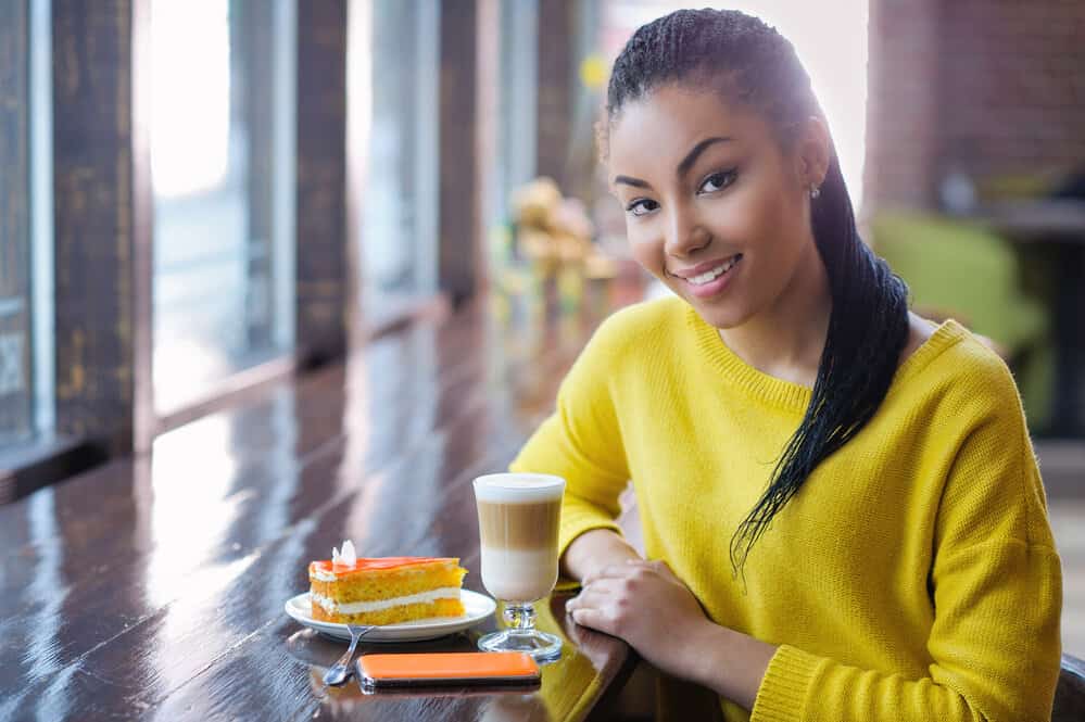 A beautiful girl on a loc journey has small locs in a ponytail style created by a licensed cosmetologist.