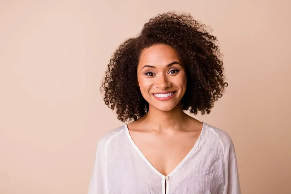 How Coconut Oil Ruined My Hair: The Dangers of Coconut Oil 1 A cheerful young black girl with healthy hair styled her natural curls with virgin coconut oil and essential hair oils.