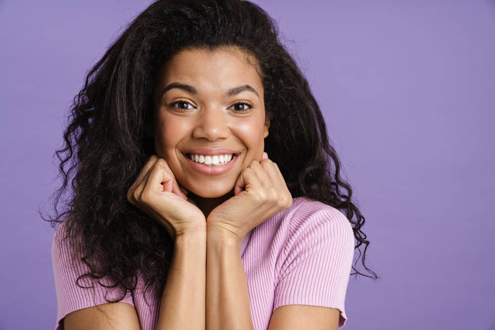 A black female with a dark brown natural color with gray roots, but it appears to be a darker color due to hair dye.