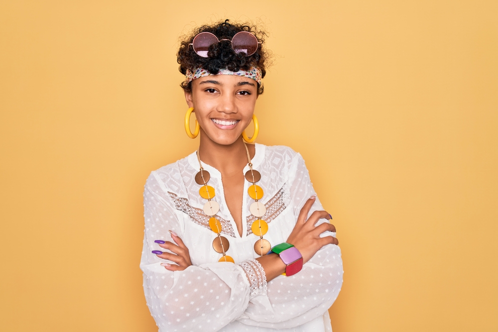 A beautiful light-skinned female wearing a shaggy bixie haircut with bangs on curly, thick hair.