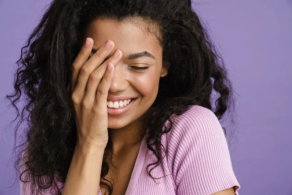 What Volume Developer Should I Use to Cover Gray Hair? | Gray Coverage 8 A young black woman with 3B natural hair just left the hair salon to have her hair dyed is covering her face.