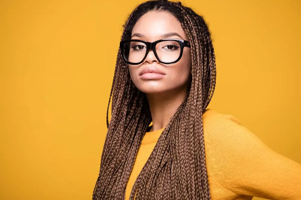 Learn How to Hide a Big Forehead With Braids Using These Styles 3 A young African American female with prominent facial features and naturally wavy hair wearing a daring hairstyle.