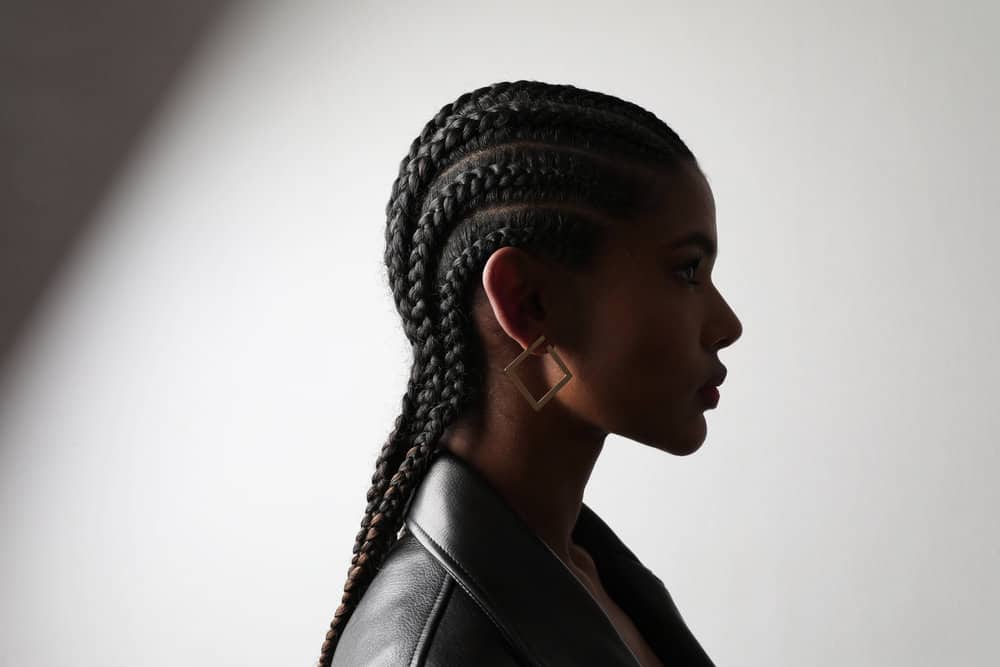 A black female wearing braided cornrows with unique and resilient hair characteristics aligned with mixed hair strands.
