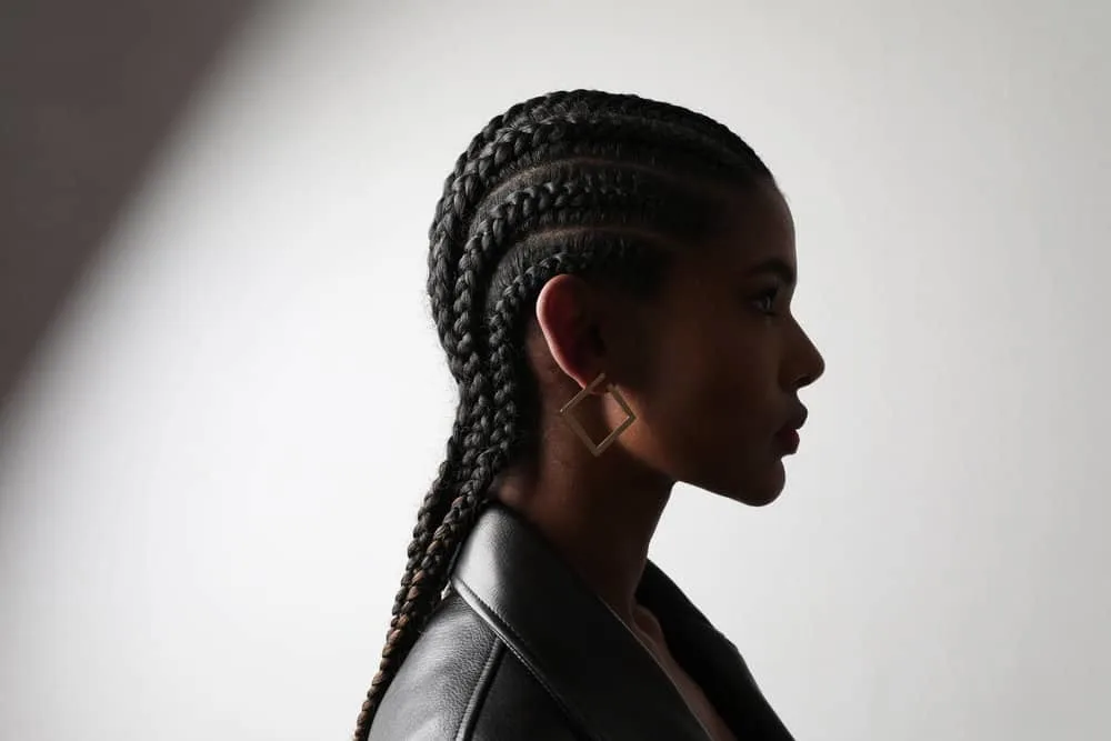 Cornrow Hair Growth Regimen: How Long to Keep Your Cornrows 2 A black female wearing braided cornrows with unique and resilient hair characteristics aligned with mixed hair strands.