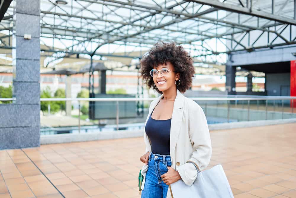 A black woman at the mall picked up some hair products to bleach hair strands using a DIY hair coloring technique.