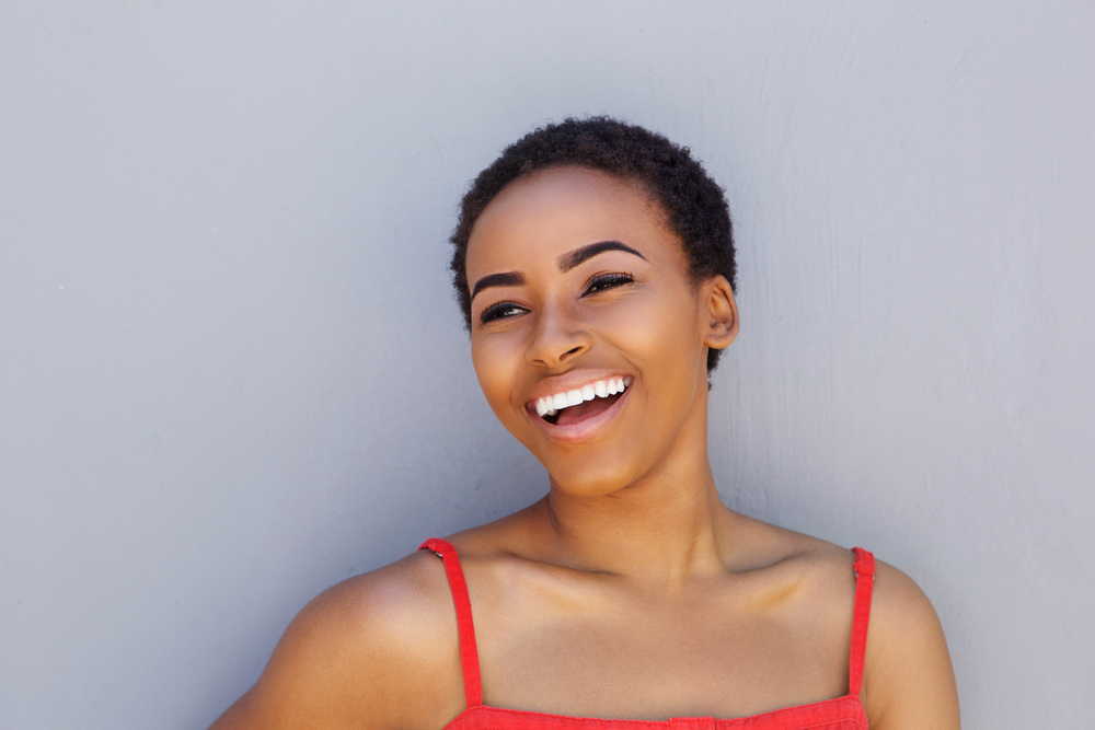 A pleasant young African-American woman with shorter hair wearing a bright red top.