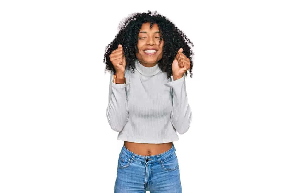 Why Is My Hair Stretchy? Is It Normal? What Does It Mean? 7 A black girl with damaged hair shafts from heat-styling tools revealed fresh hair growth.