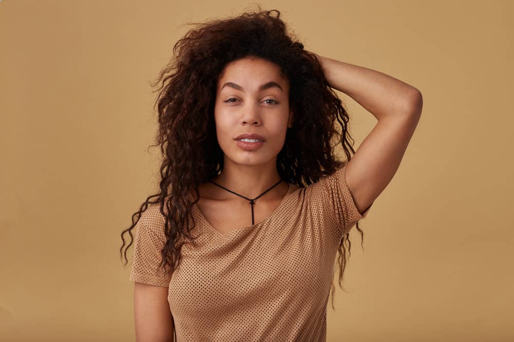 Cute young black female with fine hair wearing a voluminous blowout styled with a hairdryer brush and texture spray.