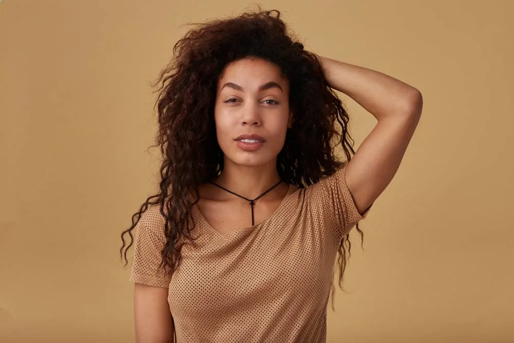 How to Do a 90s Blowout Style at Home on Short or Long Hair 1 Cute young black female with fine hair wearing a voluminous blowout styled with a hairdryer brush and texture spray.