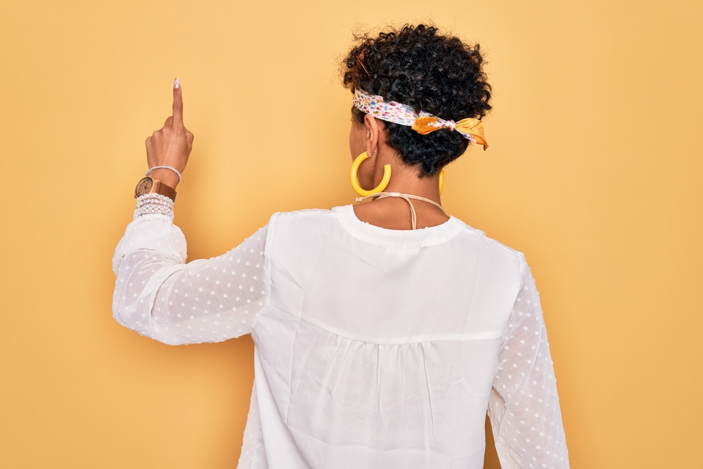 African lady with thick hair wearing a jaw-length bixie styled with a styling cream to add personality and softness.