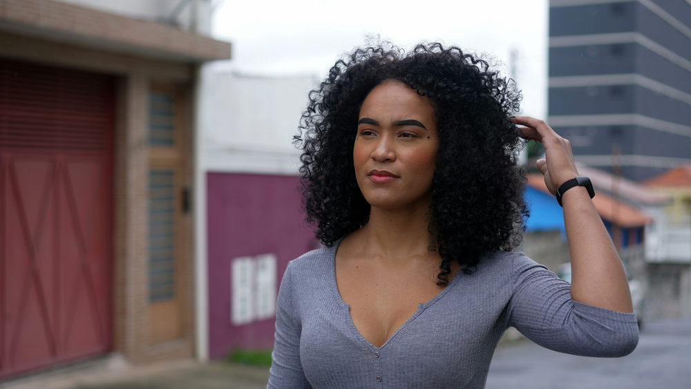 Cute black girl with tight curls treated with a deep treatment Masque Oribe and soybean oil.