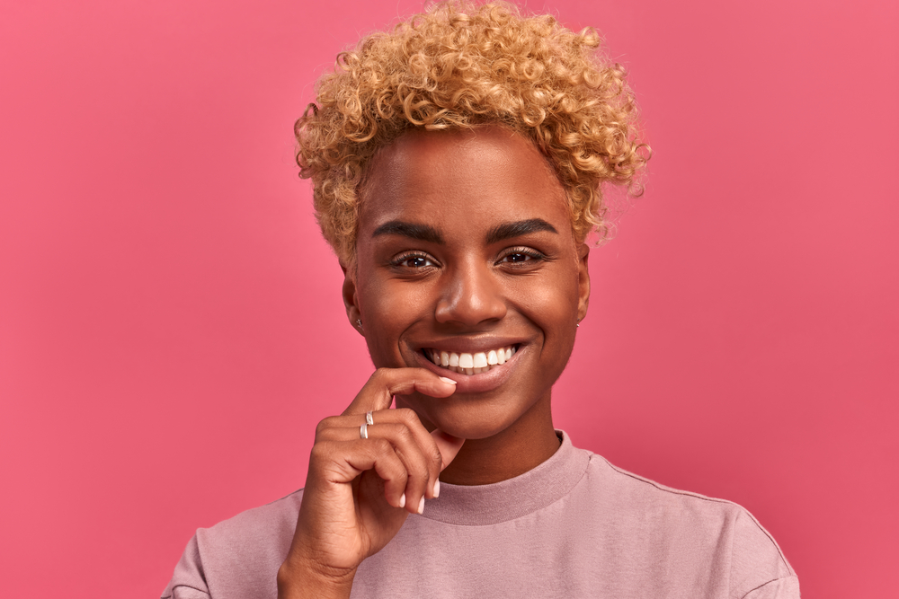 Cute black girl with extremely curly hair styled with mineral oil, lanolin wax, and organic compounds.