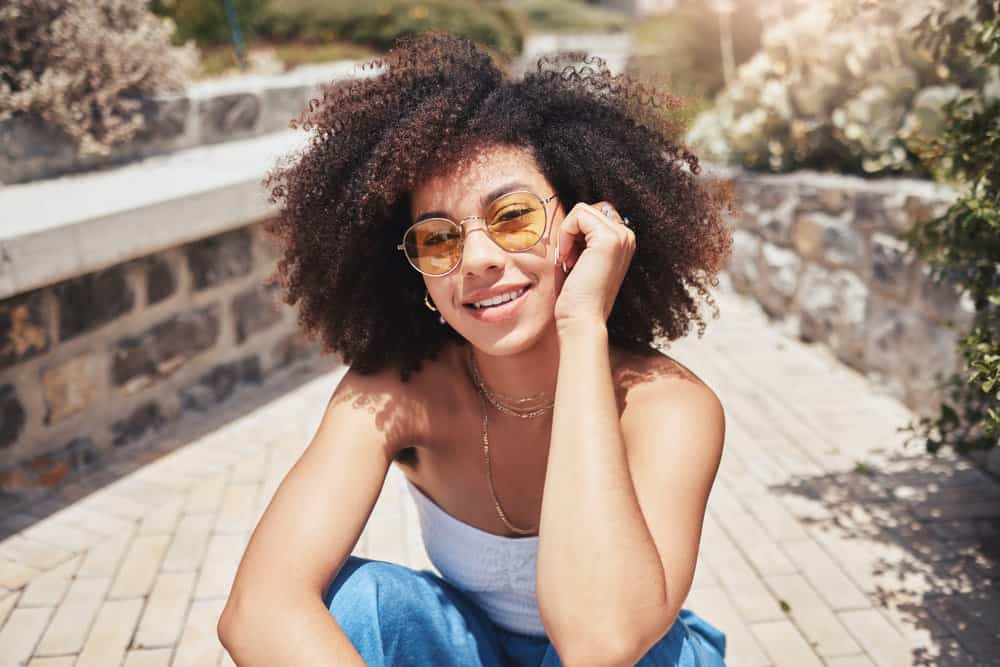 A trendy mixed-race female found shea butter beneficial after experiencing hair breakage on her frizzy hair.