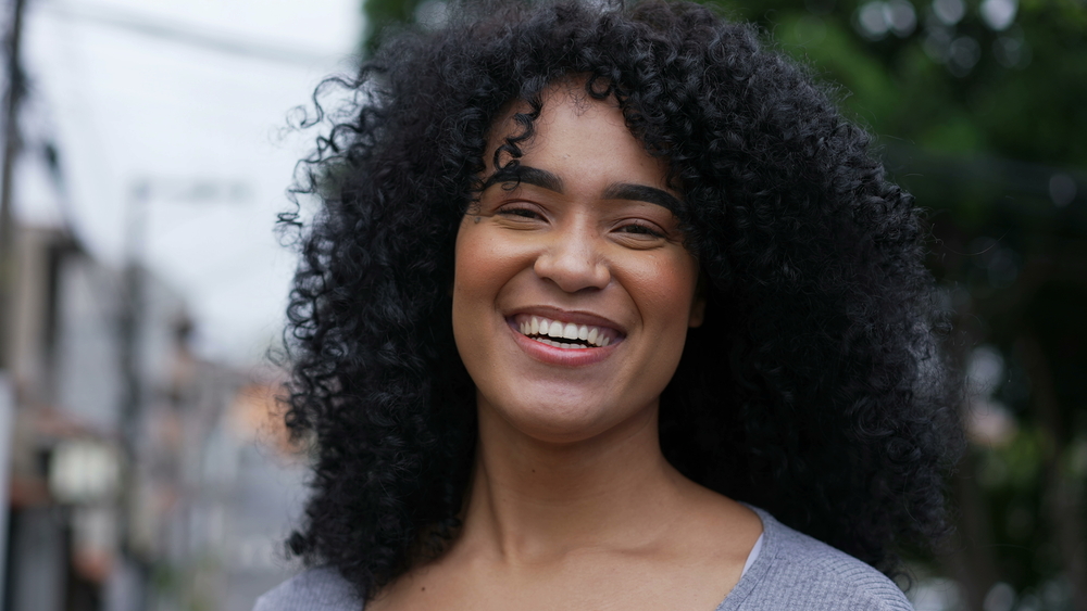 A black girl with kinky hair styled with coconut oil and sweet almond oil as she posing for a series of YouTube videos.