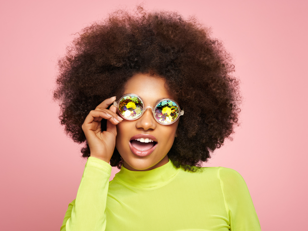 A lady wearing a cute ombre hairdo created by a celebrity hairstylist using hair products designed for 4A curls.