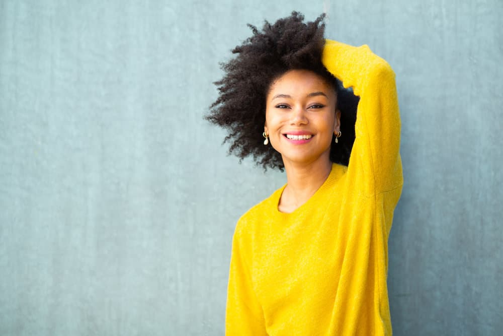 A young black girl with type 4 hair strands styled with a leave-in moisturizer and other natural hair care products.
