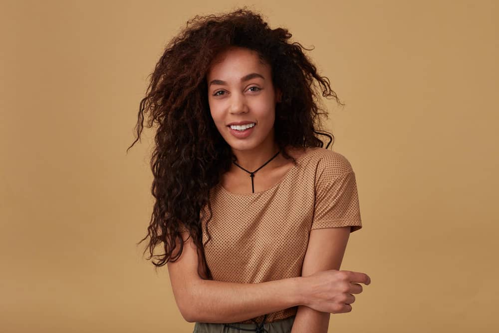 A beautiful young long-haired lady with natural curls wearing a casual hairstyle.