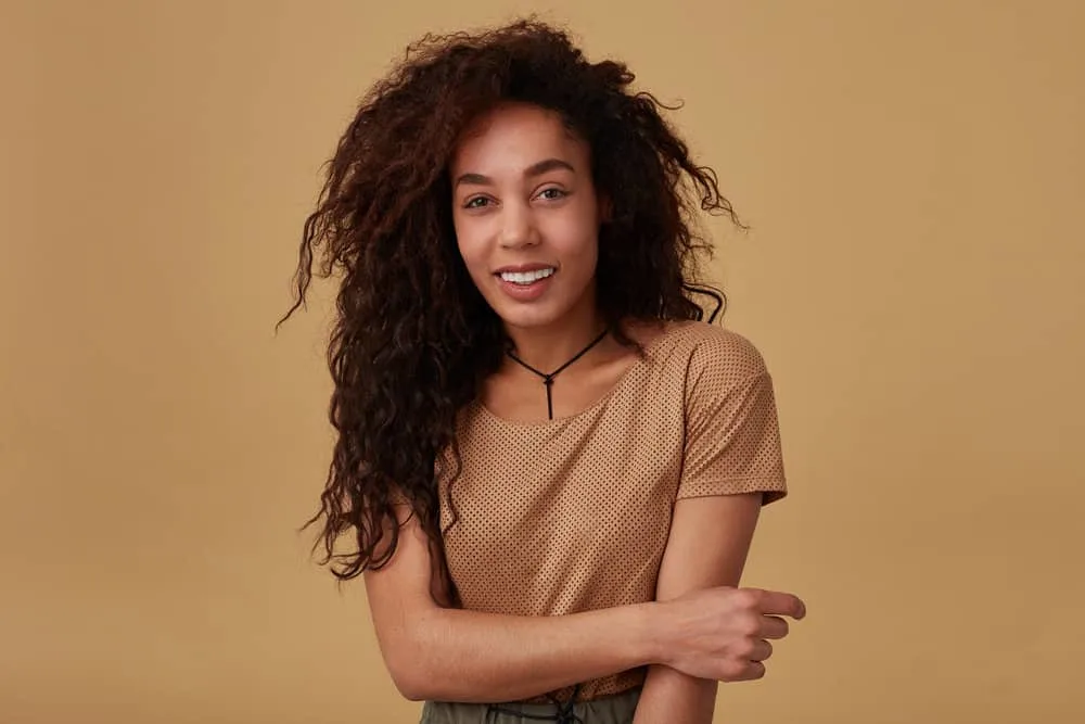 How to Do a 90s Blowout Style at Home on Short or Long Hair 13 A beautiful young long-haired lady with natural curls wearing a casual hairstyle.