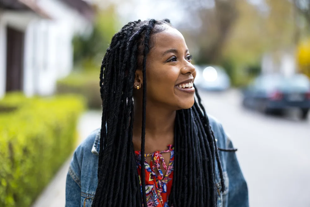 Removing Dreadlocks: How to Remove Dreadlocks at Home 3 Brown-skinned female with locked hair created on dry hair with a metal comb, olive oil, and wax.
