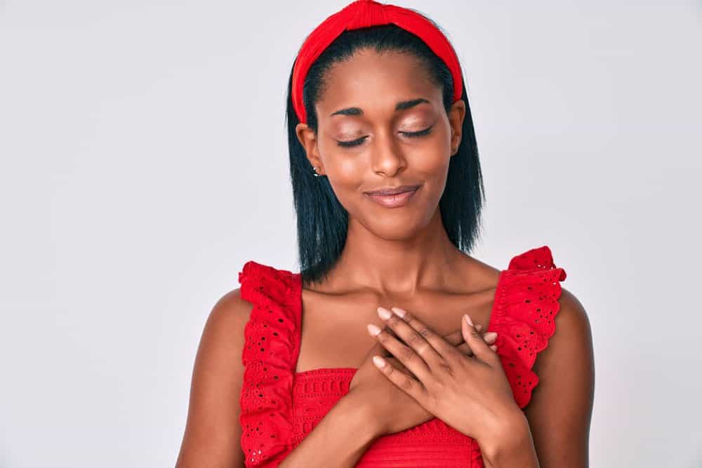 African American female after using customized Brazilian Blowout products to straighten hair strands.