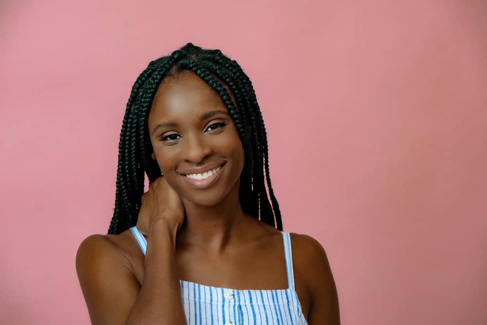 African American female wearing braided hair strands to protect her own hair and encourage hair growth.
