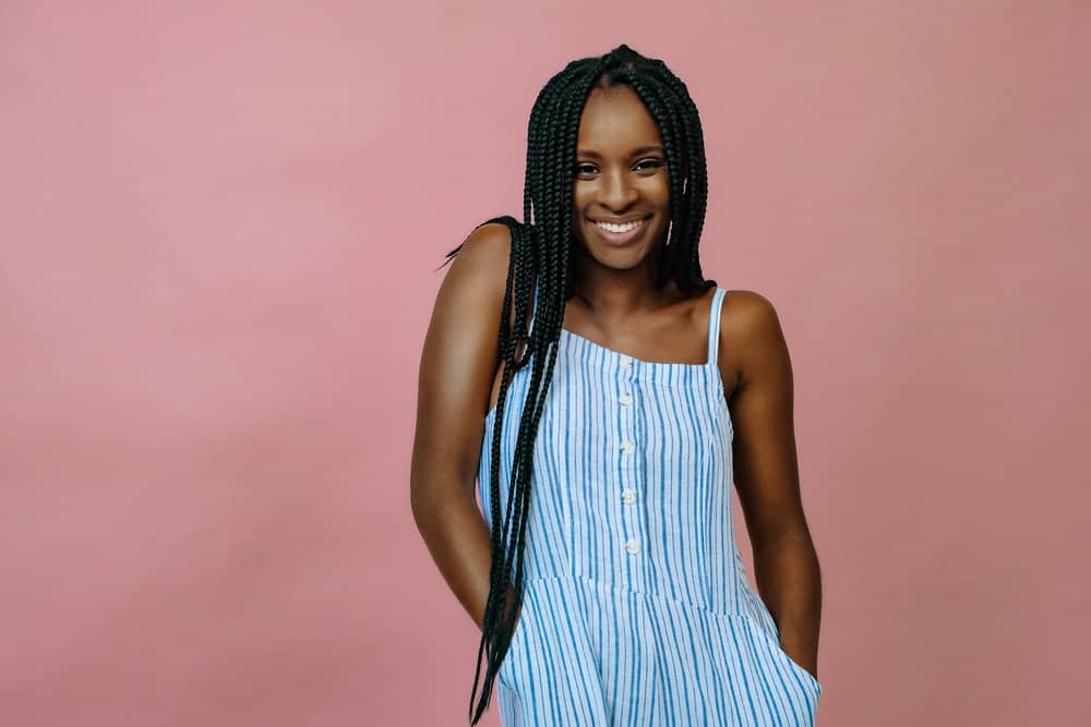 A black girl who recently used a clarifying shampoo wears a braided protective style on her weak hair.