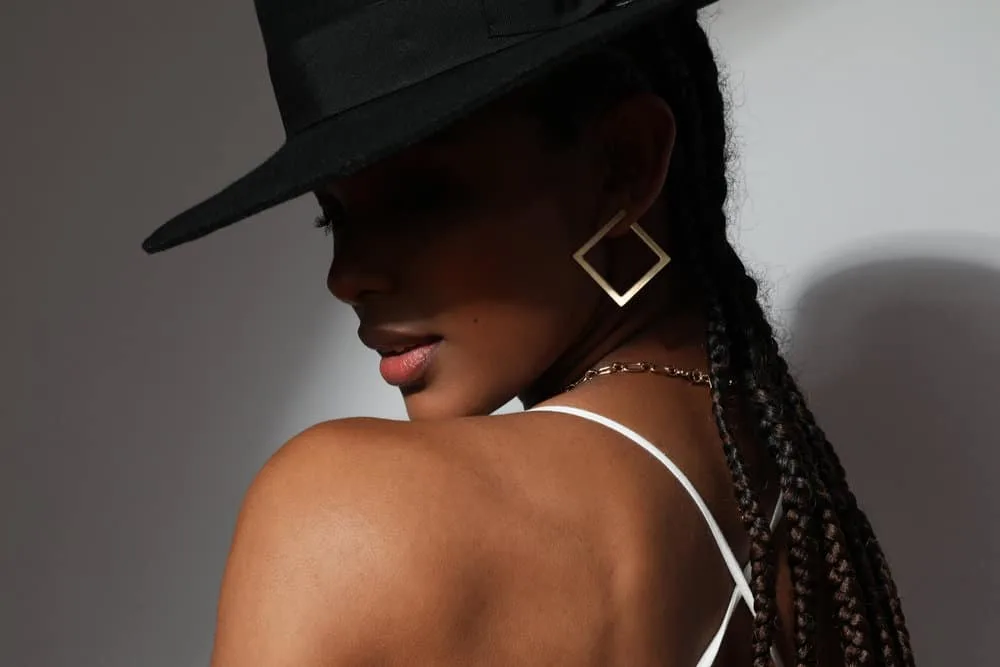 Side view of a black lady wearing an increasingly popular braided style designed to help her retain length.