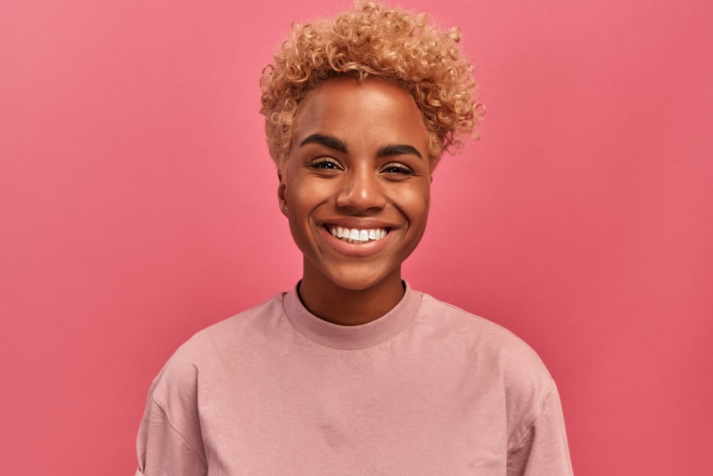 A lady with color-treated soft hair smiling after recovering from lanolin allergies after she accidentally ingested lanolin.