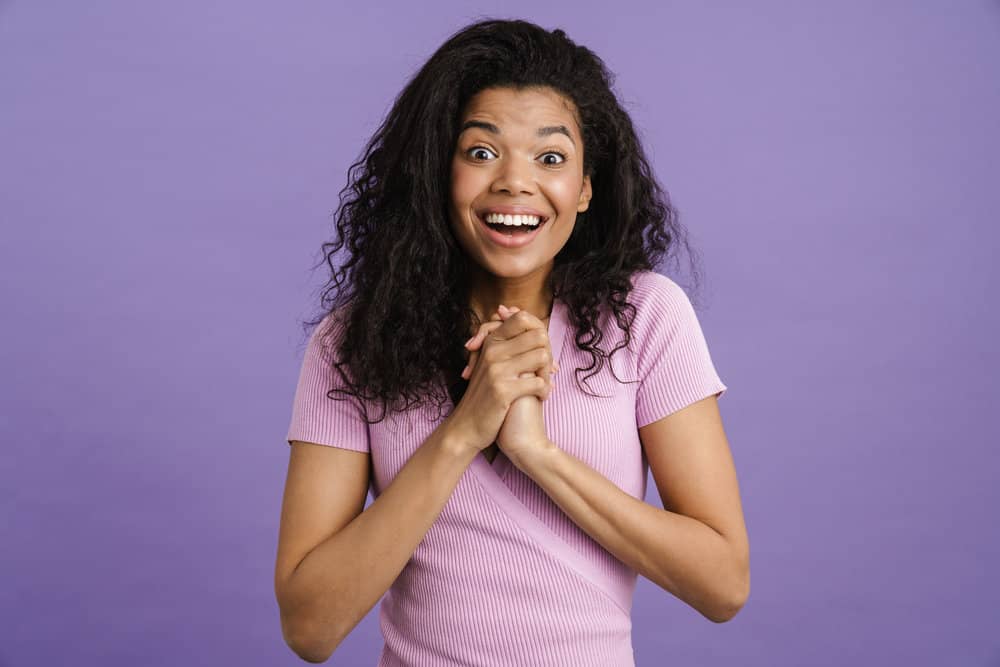 A cute young black female with emerging grayish-white hair in the root area of her kinky-curly 3B hair follicles.