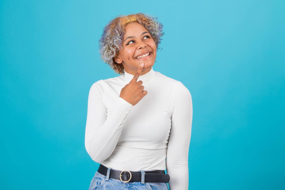 A black female with a blonde hair section (like a mohawk) and lite blue/purple color fading strands on the sides.